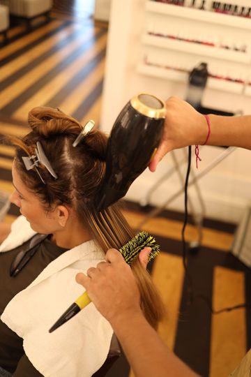 Profissional fazendo escova em uma cliente