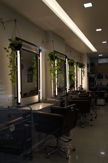 Fileira de espelhos com luz e plantas penduradas ao longo do salão do Constant Plaza
